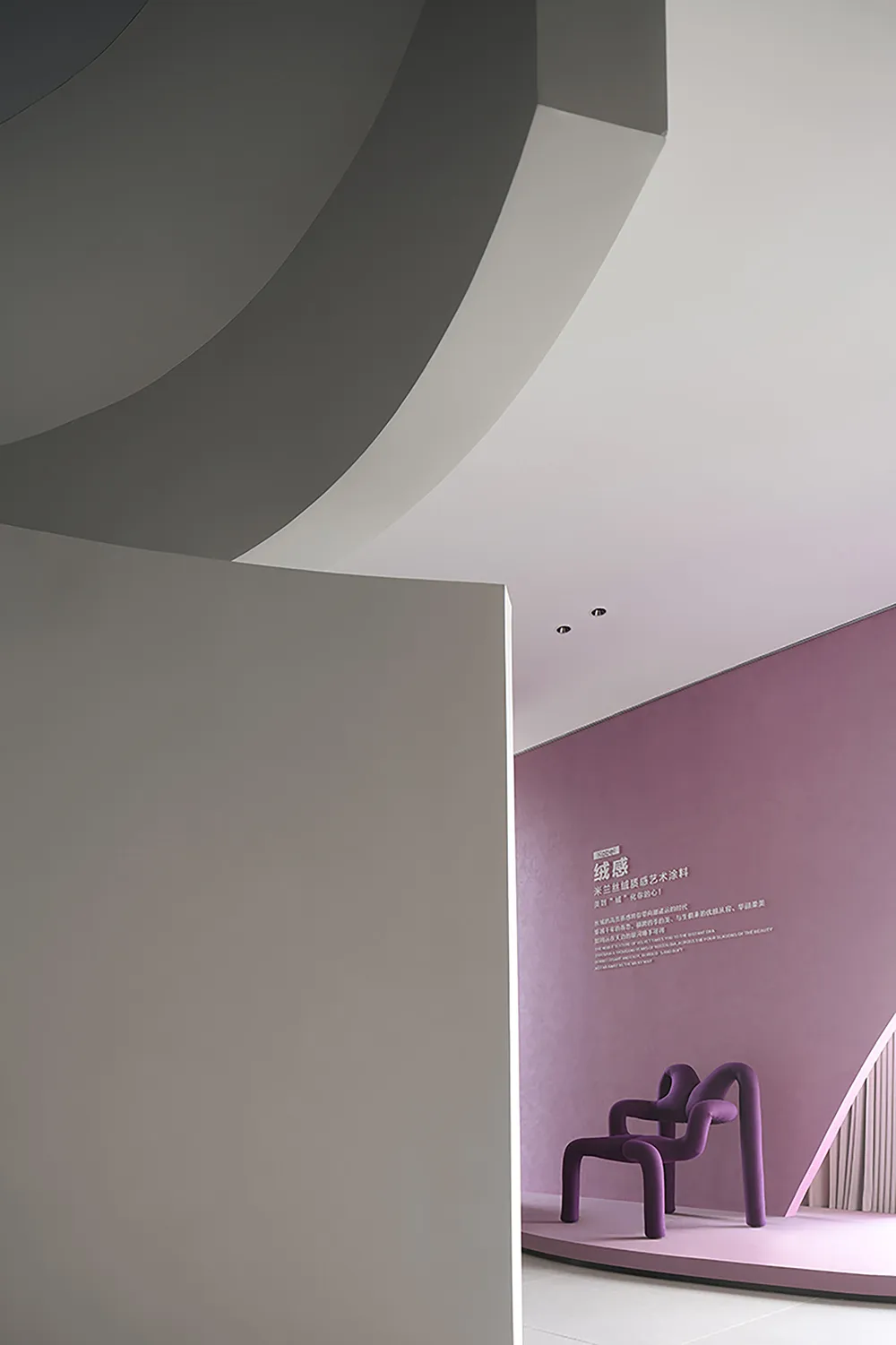 A modern, purple-themed room featuring unique, sculptural furniture covered in velvet upholstery.