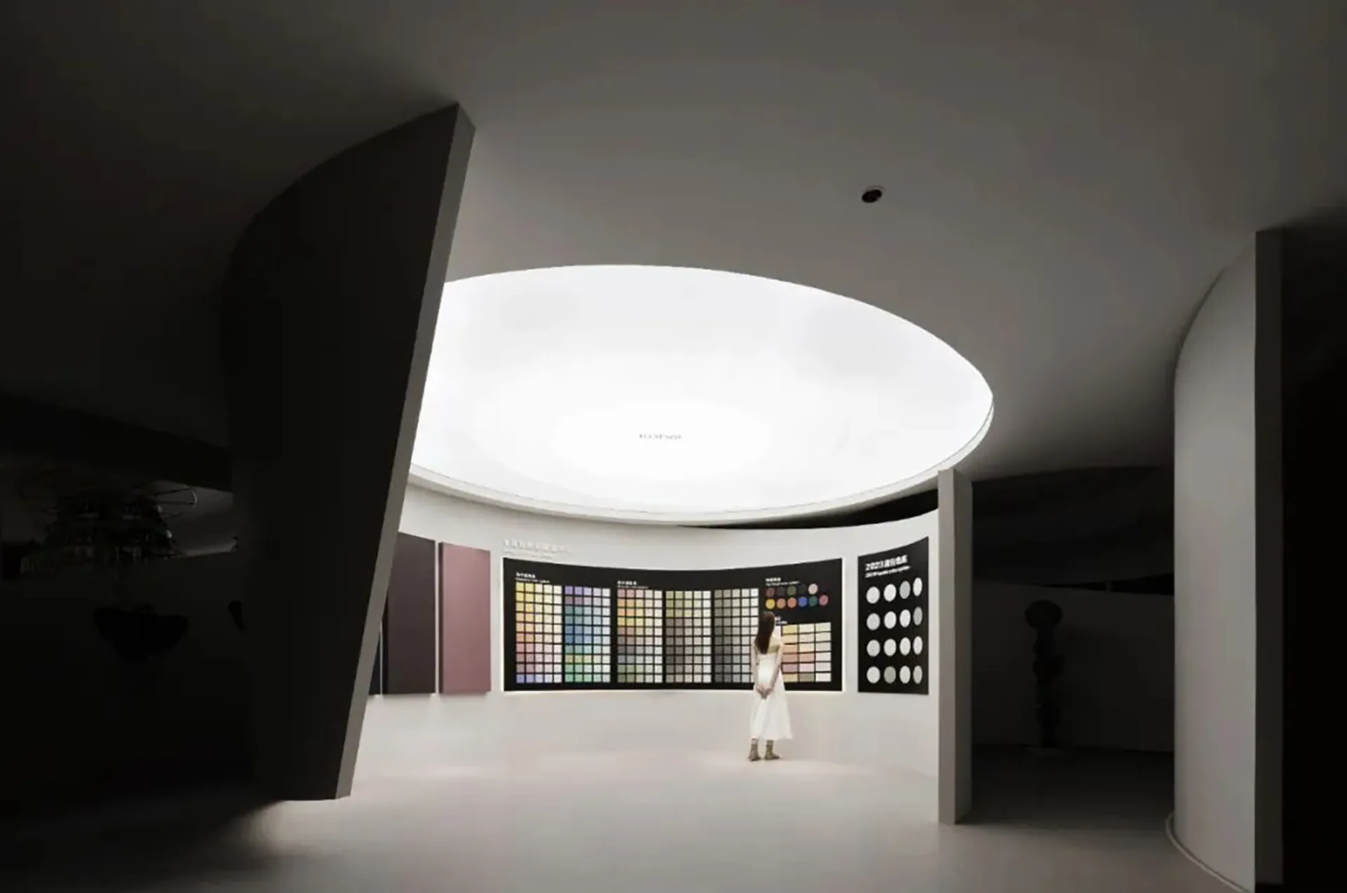 極簡室內設計空間,白色牆面、混凝土柱,以及圓形色彩樣本展示。