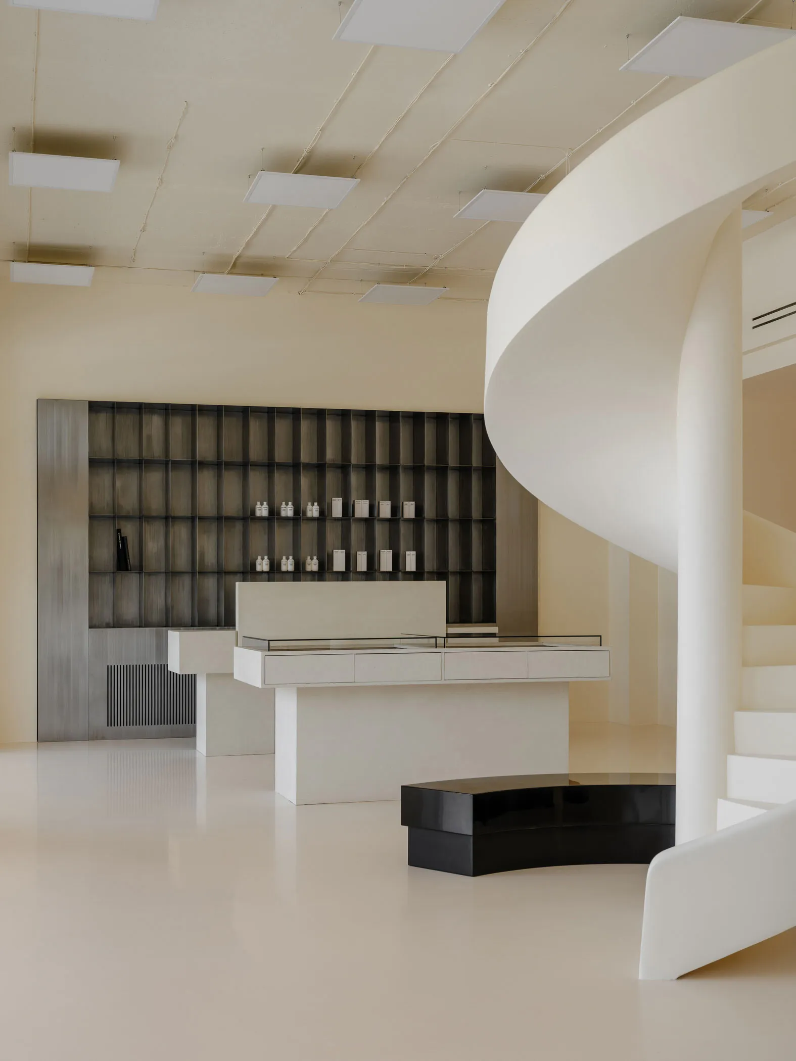 Modern retail interior space featuring concrete, glass, and metal elements.