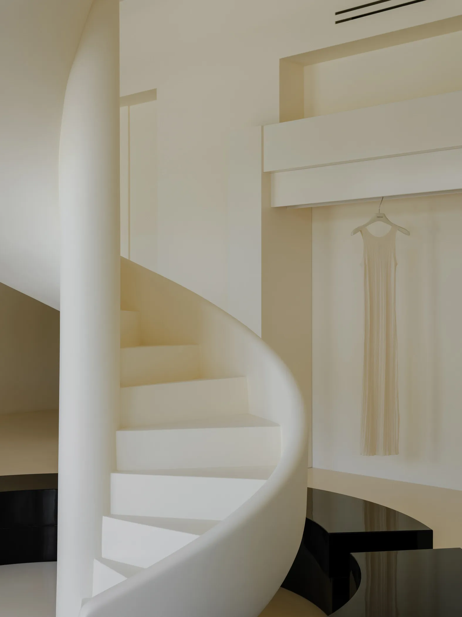 White concrete spiral staircase in a minimalist interior design