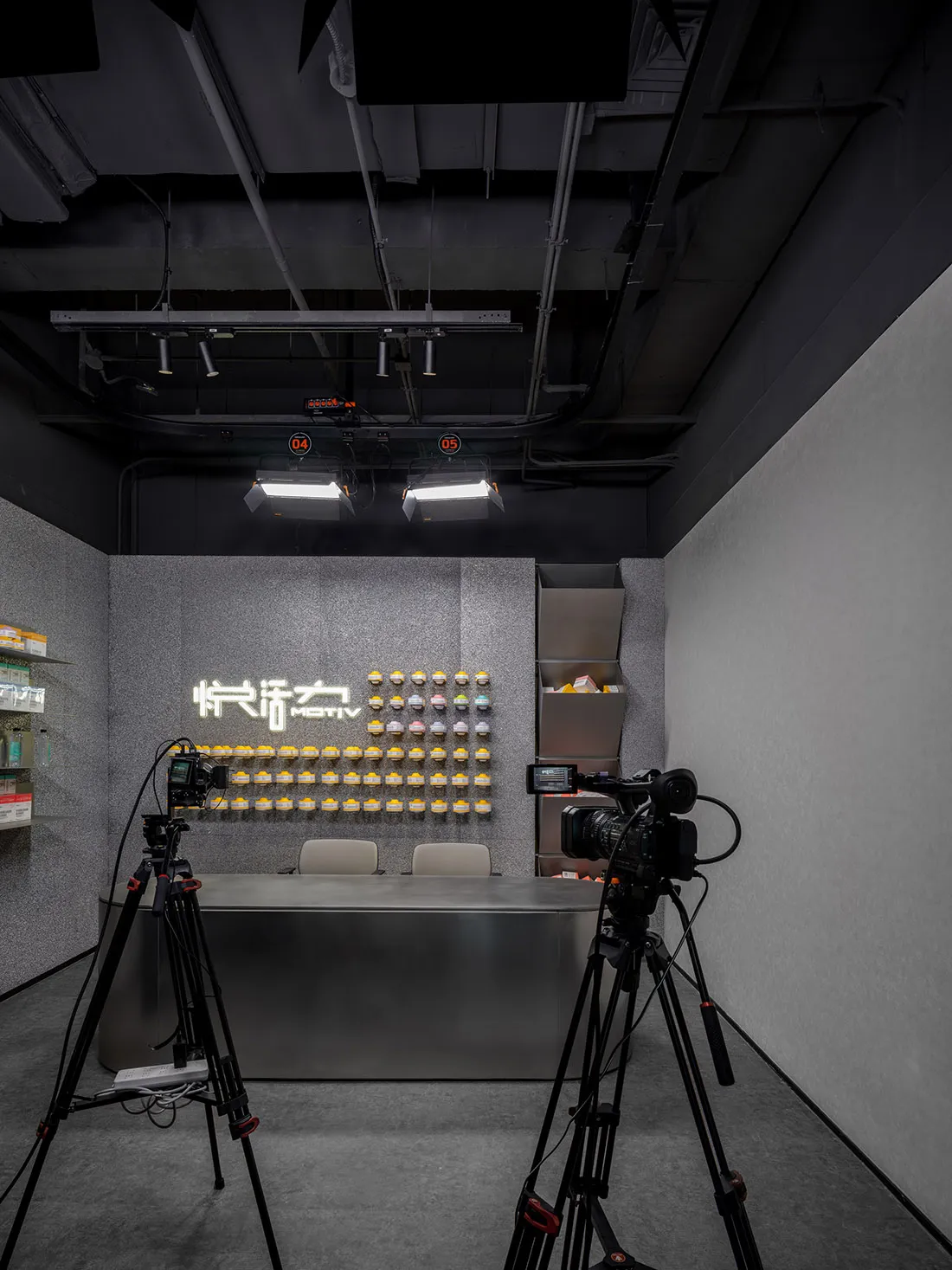An industrial-style retail space featuring a concrete wall with a neon sign and yellow products displayed on shelves.