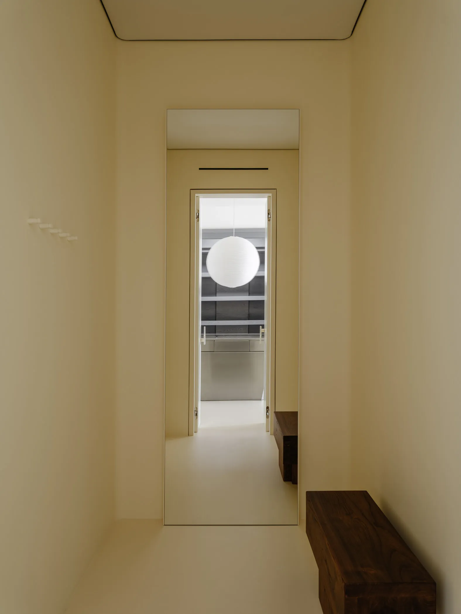 Minimalist modern interior with a white spherical pendant lamp and sleek furniture.