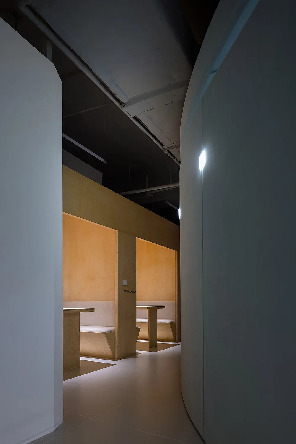 Modern restaurant interior with wooden furnishings and seating.