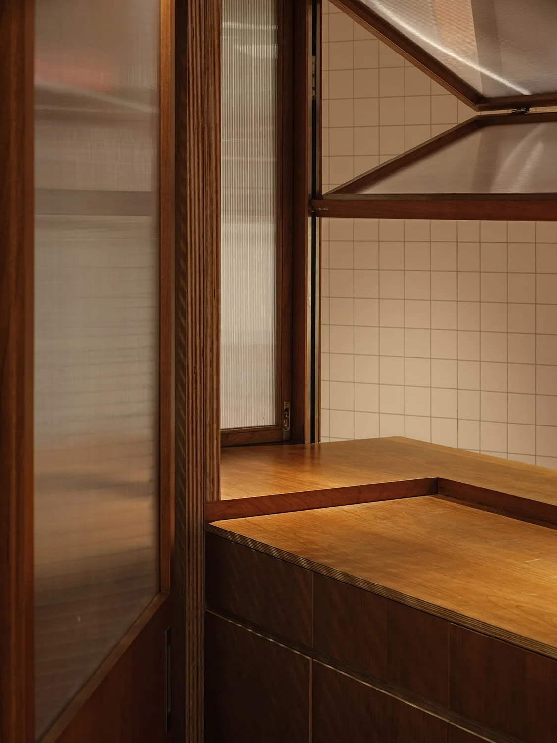 A modern, minimalist interior design featuring wood and glass elements.