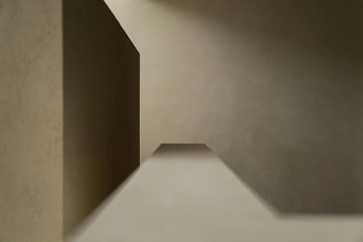 A minimalist architectural space with concrete walls and a white floor.