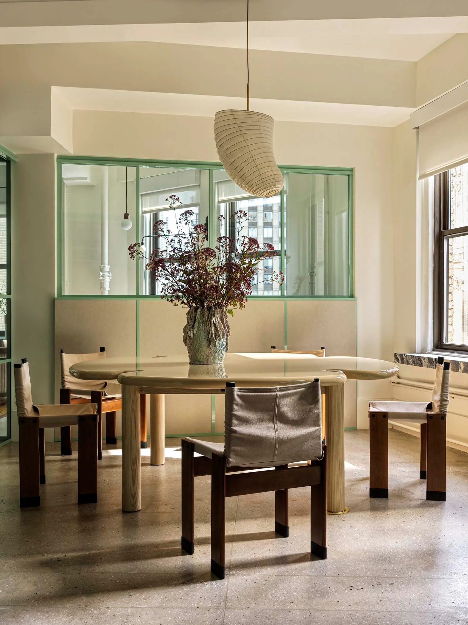 Modern dining room with an integrated glass window and wooden furniture.