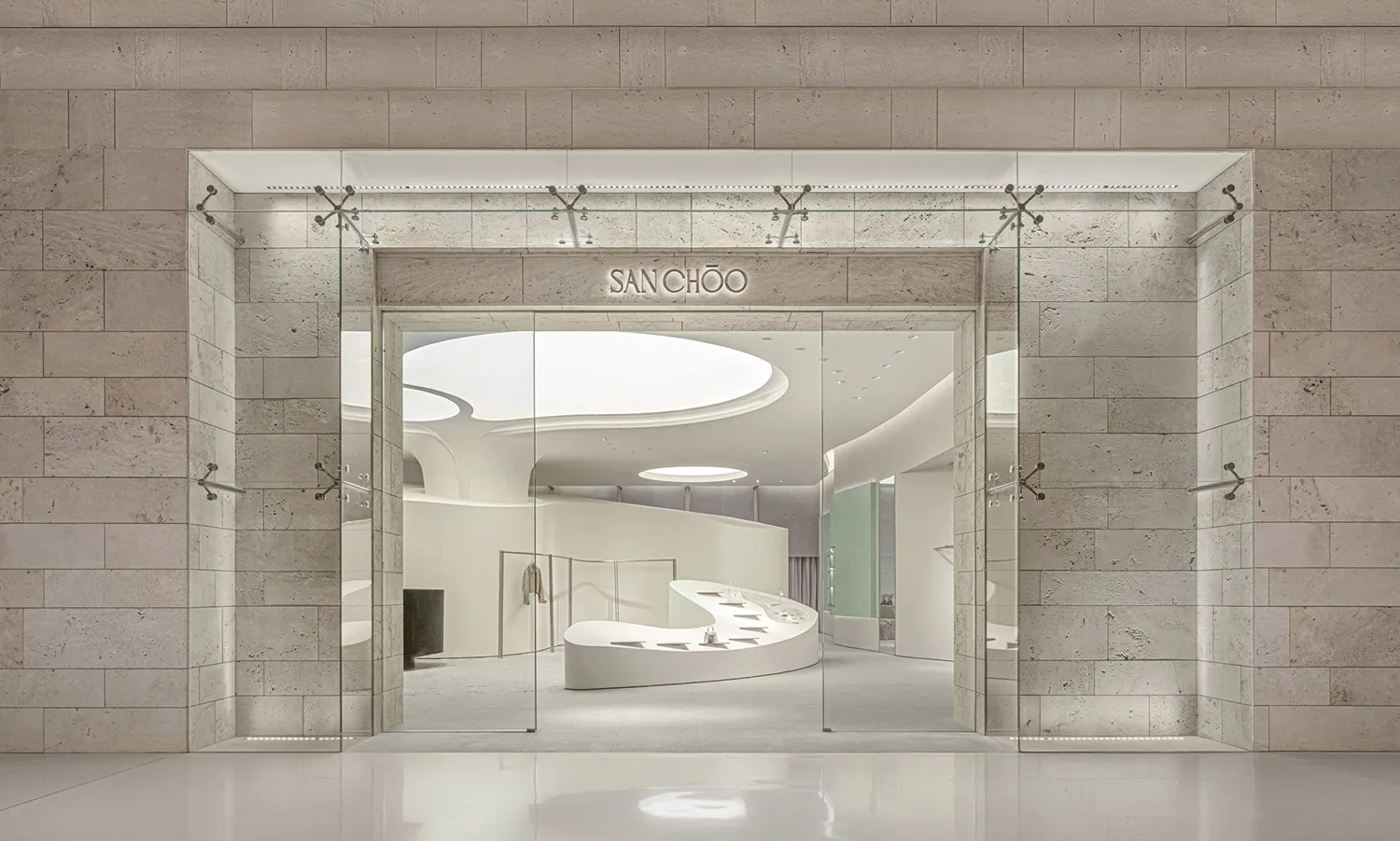 Modern, minimalist retail storefront with frameless glass doors and a contemporary interior design.