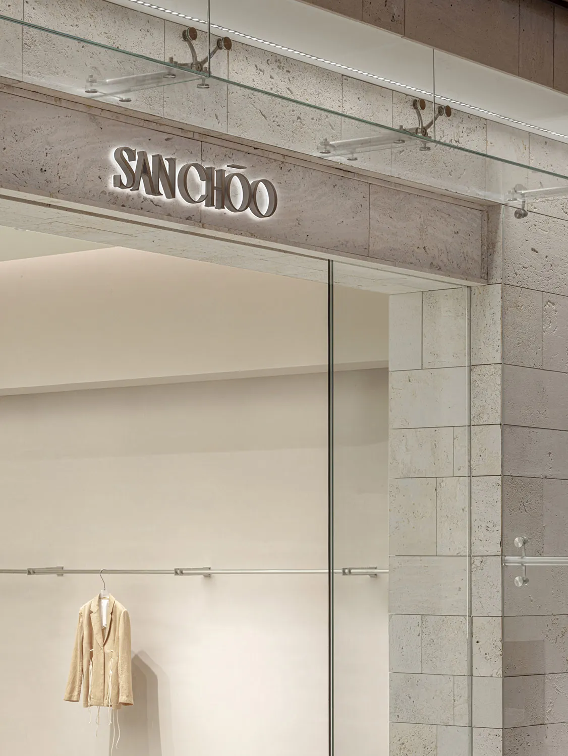 Modern retail shop interior with glass storefront and concrete accents.