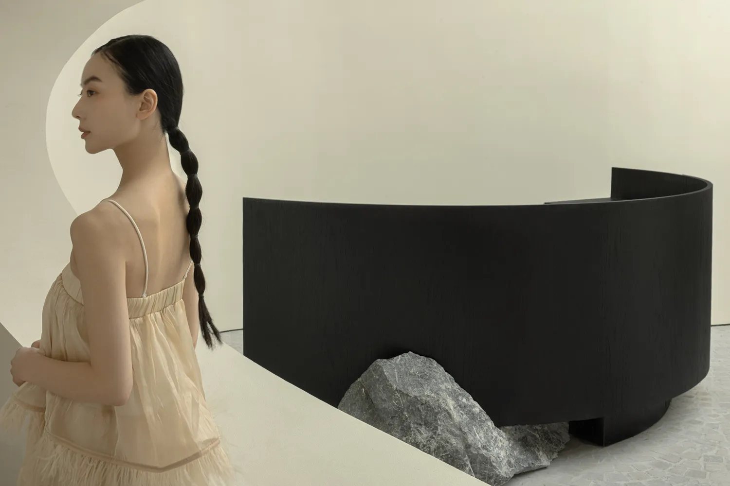 A modern office featuring a sleek, black curved reception counter with a marble base and minimalist design.
