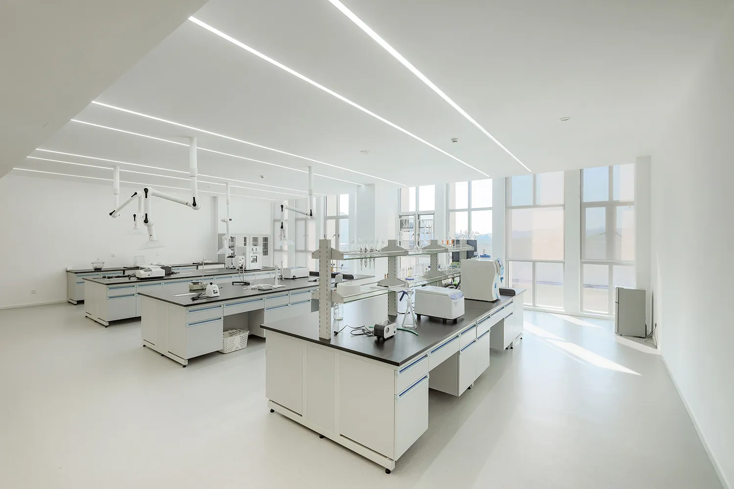 A modern laboratory with white steel and glass equipment and countertops.