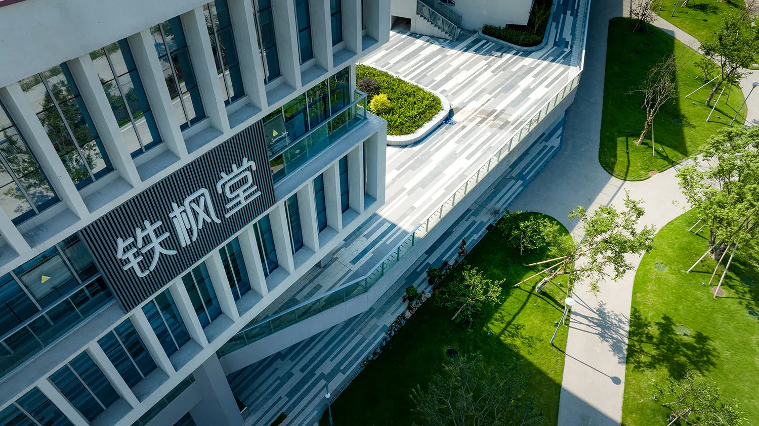 現代辦公室建築，玻璃牆面、混凝土外觀與綠意植栽