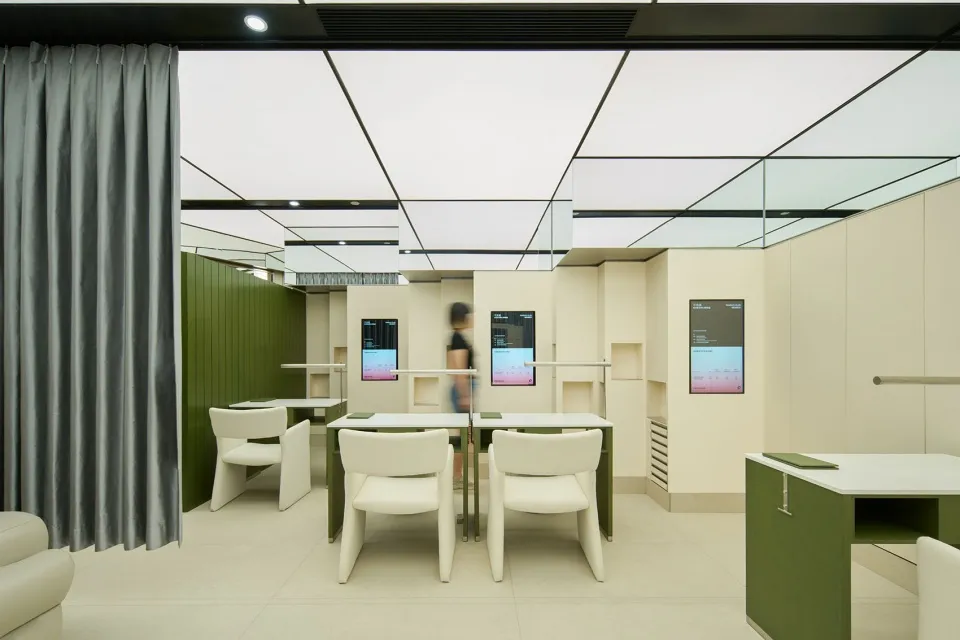 Modern office space featuring minimalist design with white furniture and green accents.