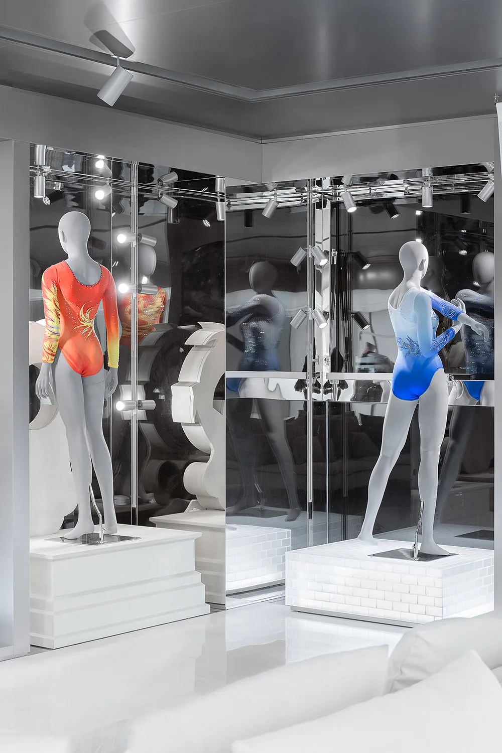 Retail display featuring mannequins wearing outfits encased in glass.