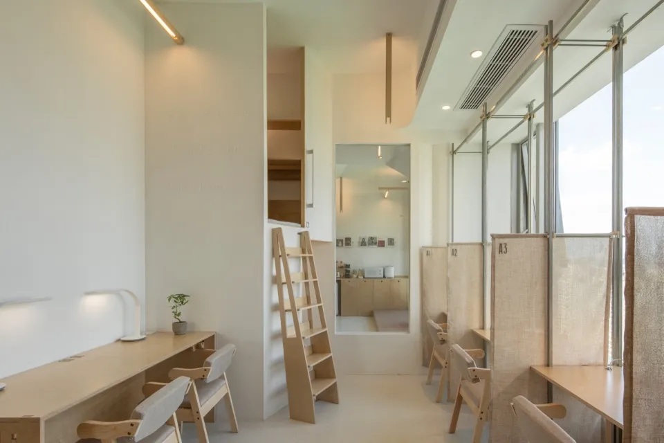 Interior of a modern office workspace featuring compact design and wood materials.