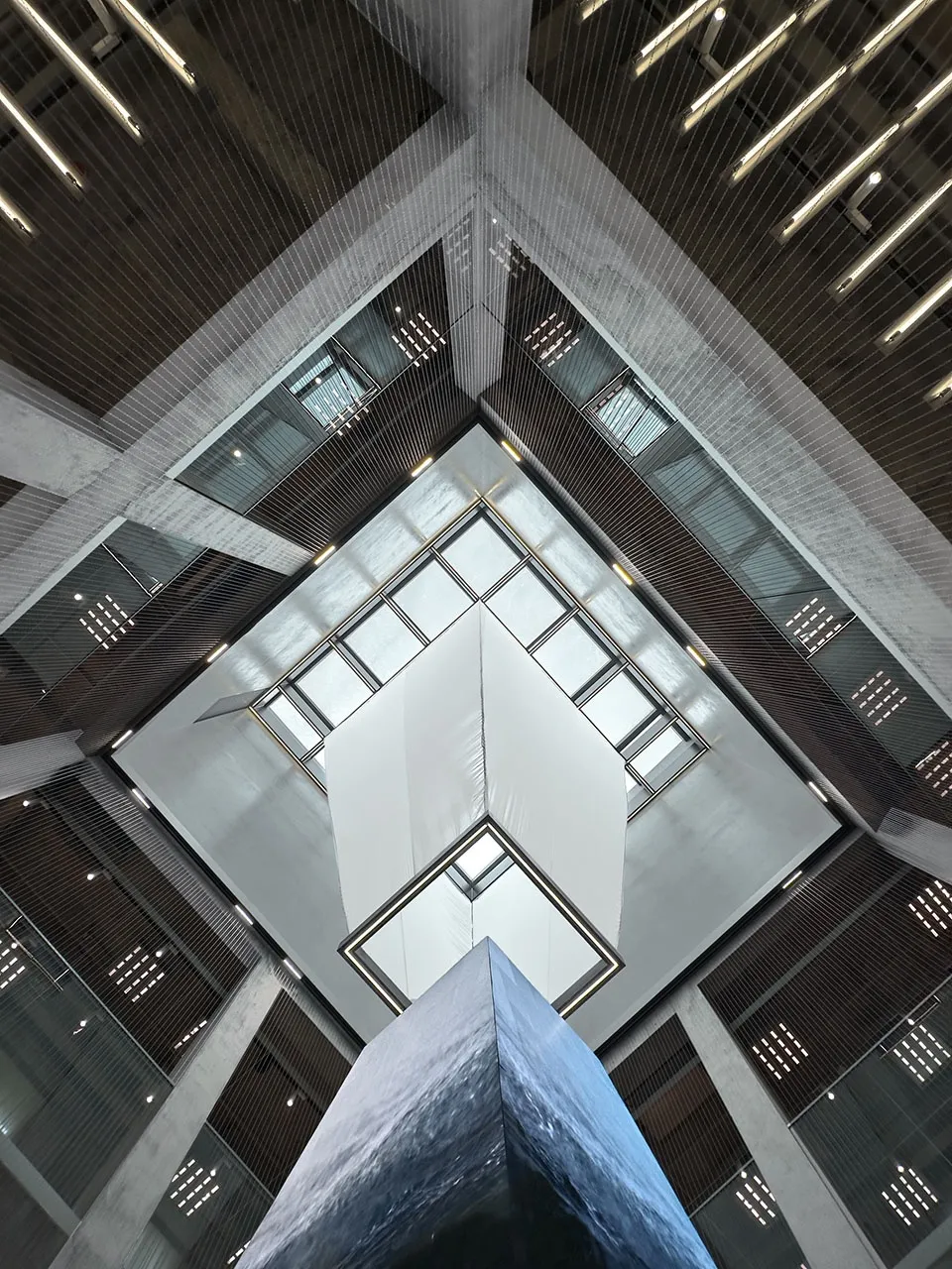 A modern office lobby features sleek glass and concrete materials, creating an open and airy atmosphere.