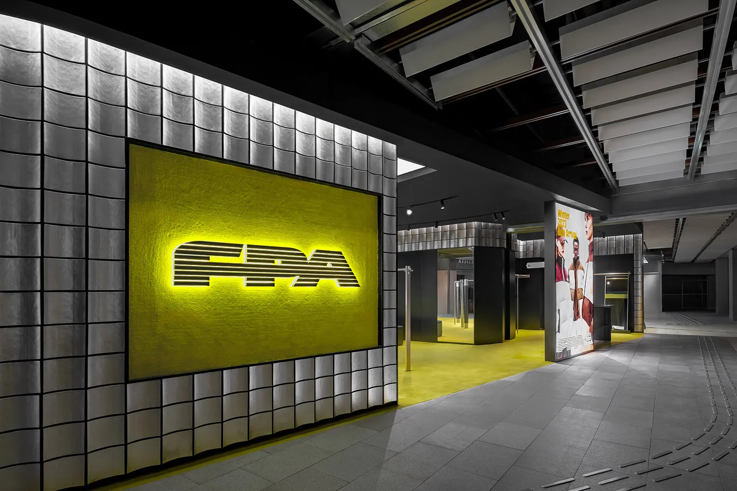Modern retail storefront with a concrete wall and an illuminated signboard.