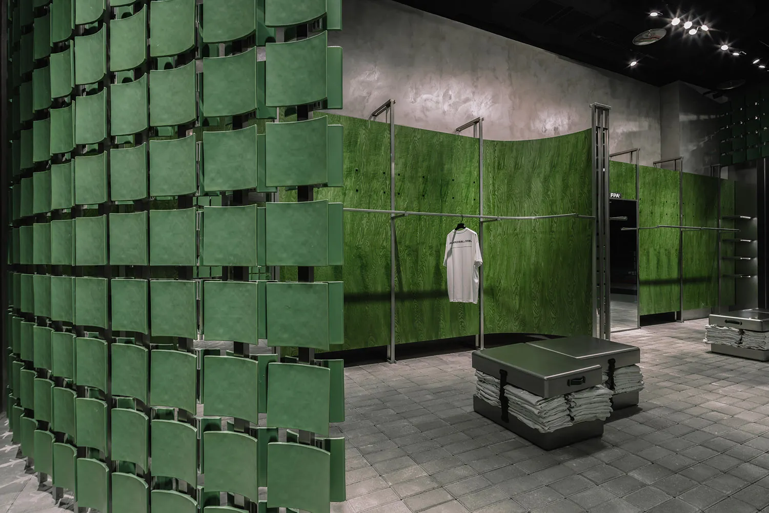 A retail storefront featuring a wall of green metallic panels.