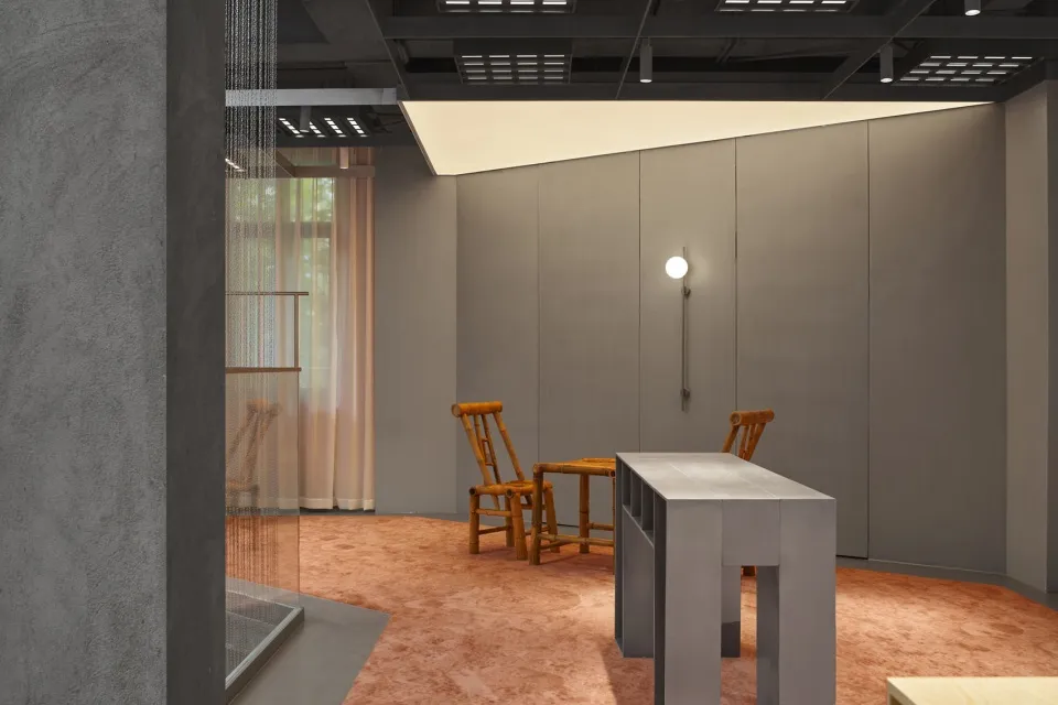 A minimalist office space featuring modern concrete and wooden furniture.