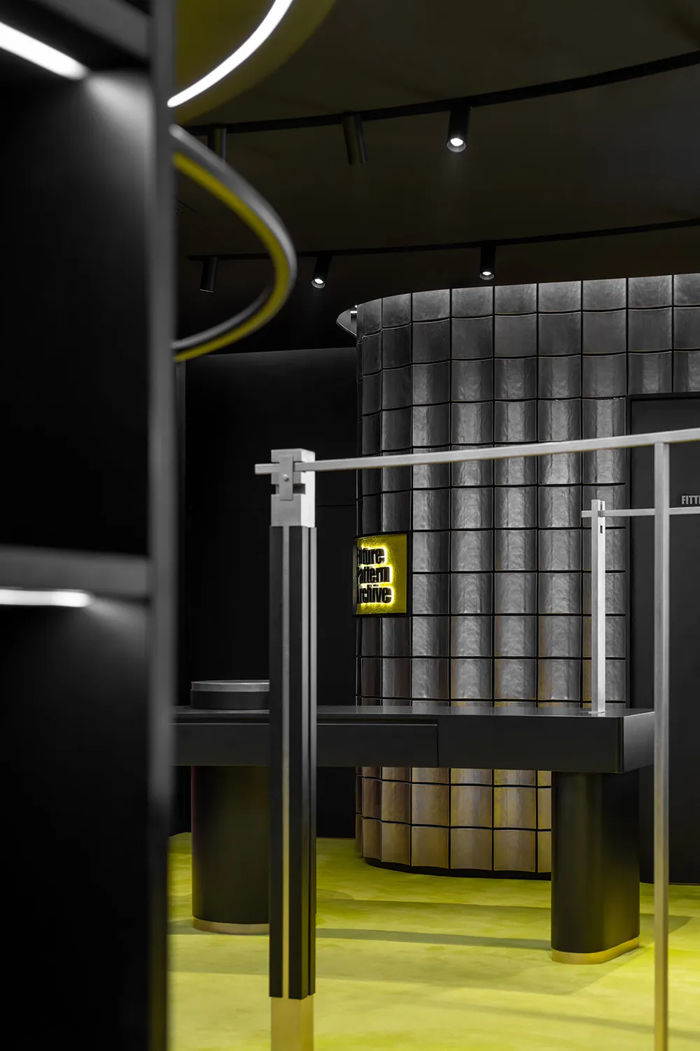 A sleek, modern retail display featuring metallic surfaces, glass panels, and illuminated neon elements.