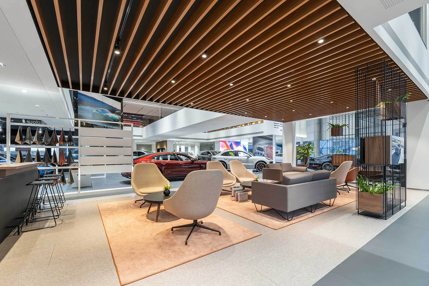 Modern interior of a car showroom featuring a wooden ceiling and comfortable seating.