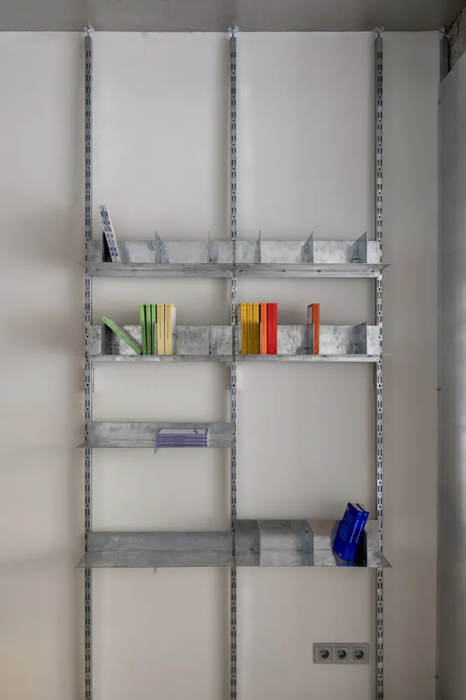 A metal shelf unit with various books and items placed on it.