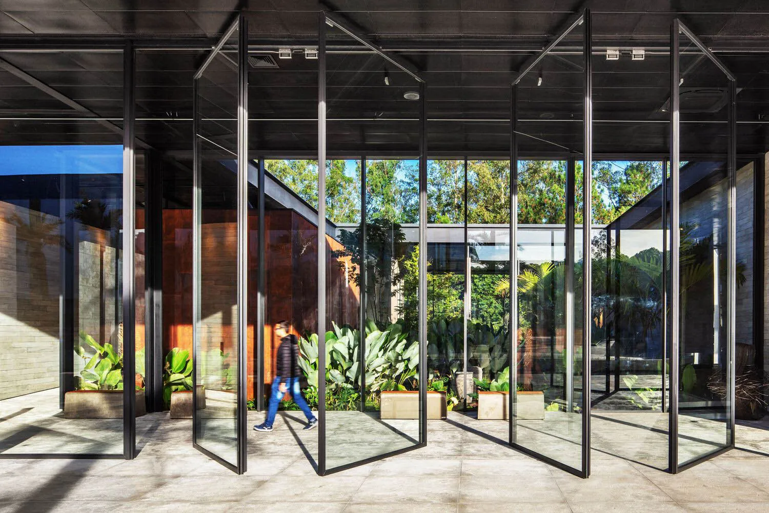 Modern interior design featuring glass, concrete, and wood materials.