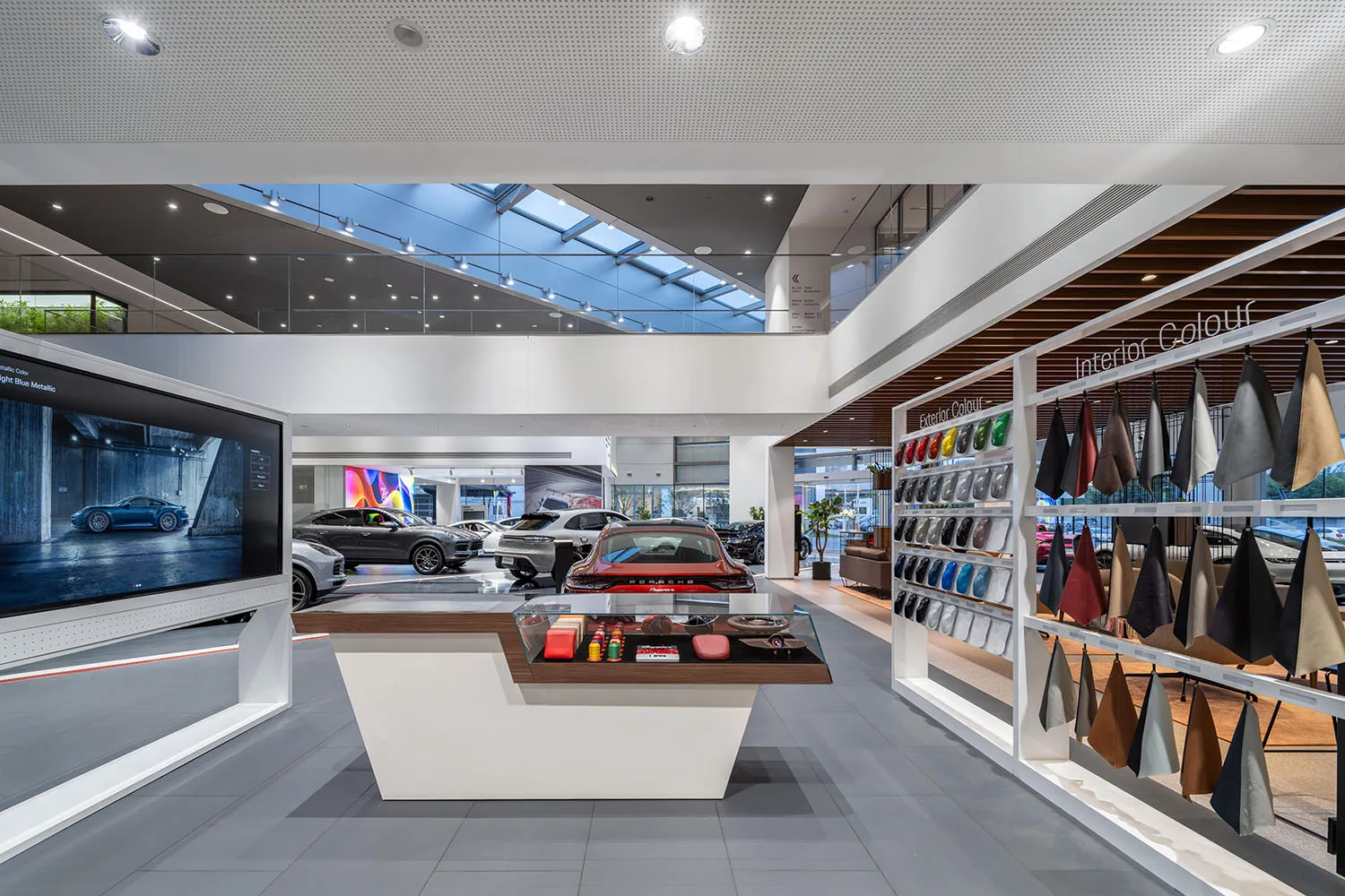 Modern interior design of a car dealership with a display of cars and color samples.