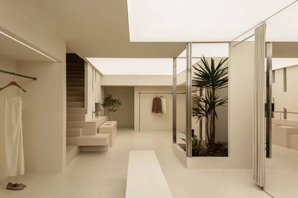 A minimalist clothing retail space with neutral tones and modern design.