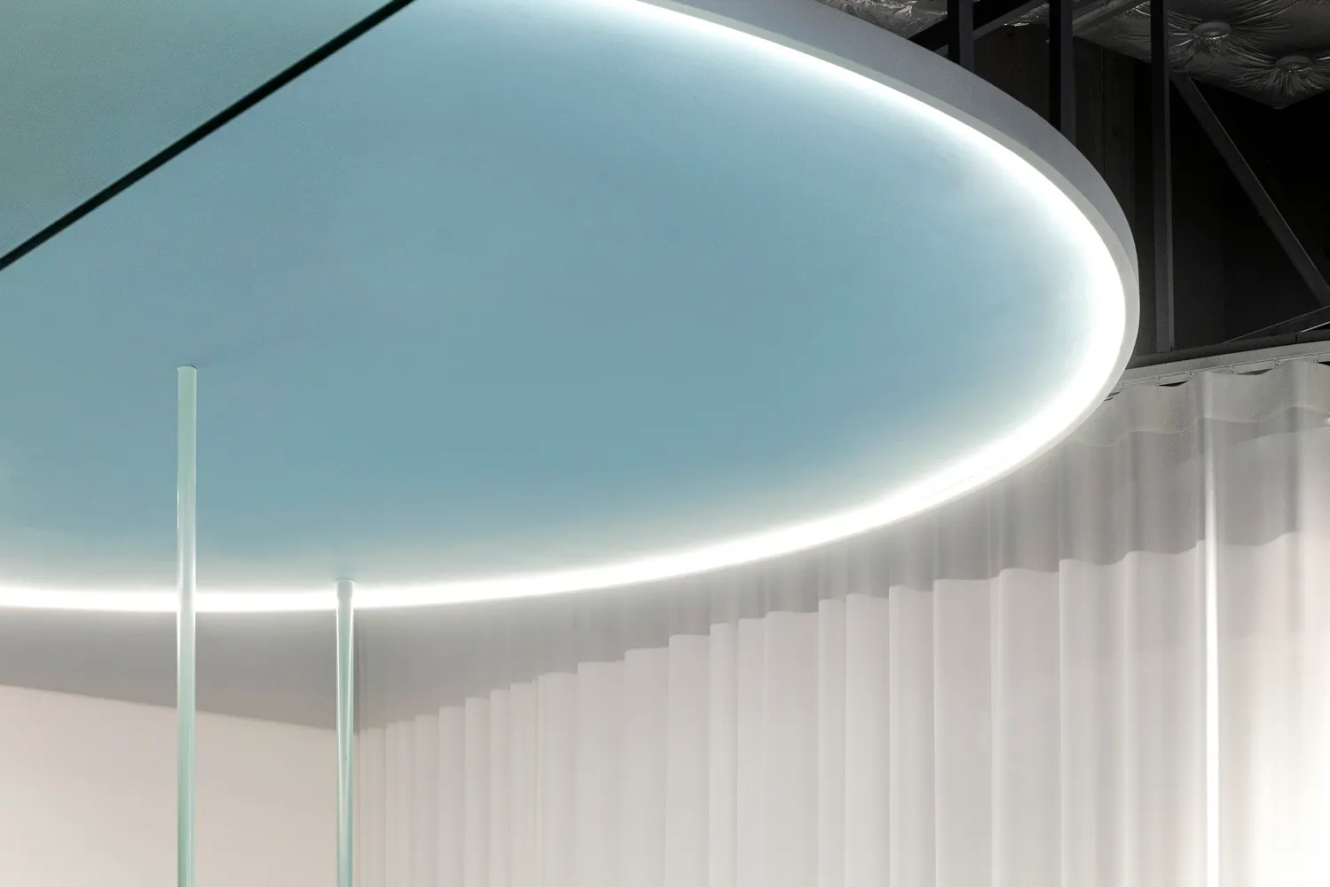 Modern office space featuring transparent glass curtains and a sleek, minimalist design.