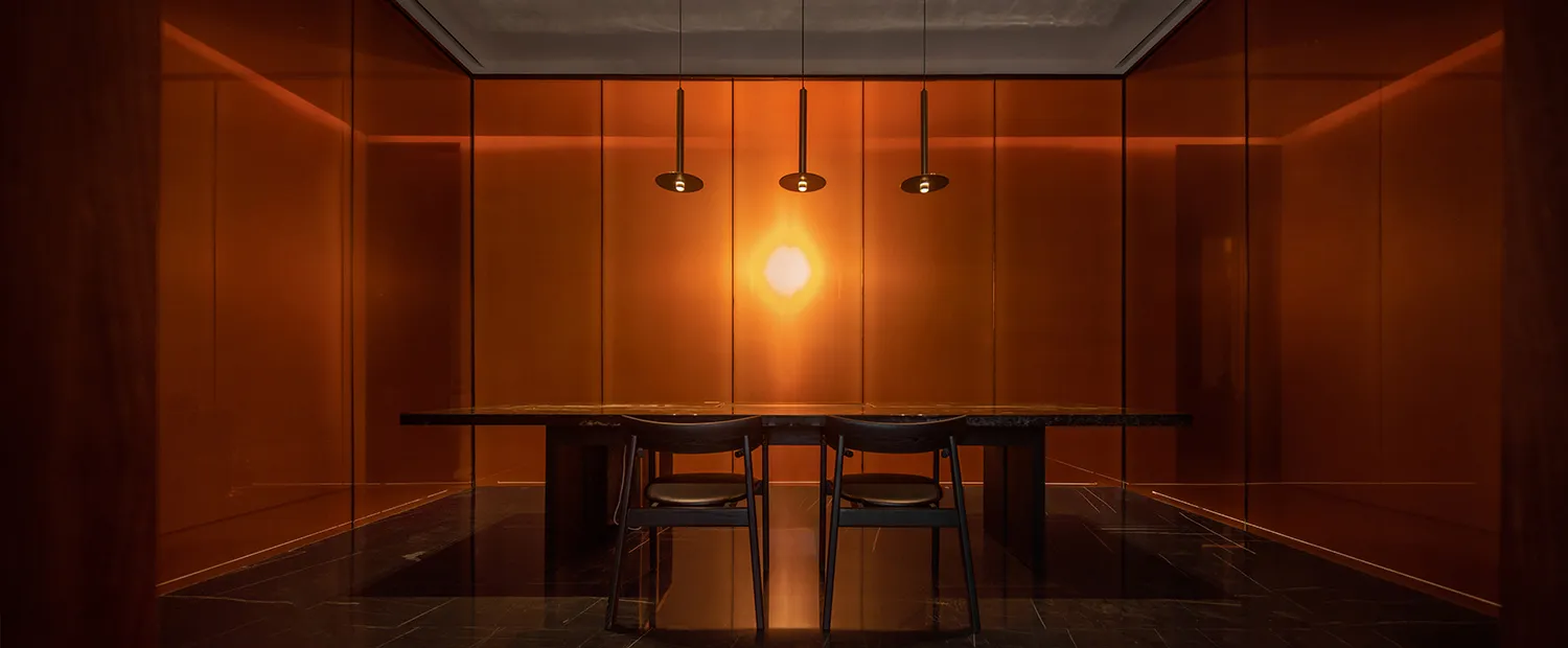 Minimalist dining room with glass walls and a black marble table.