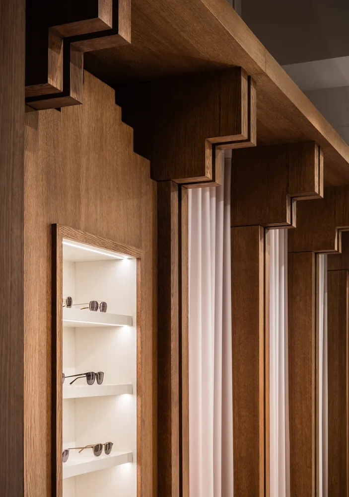 A modern retail shop showcasing wooden shelves with sunglasses.
