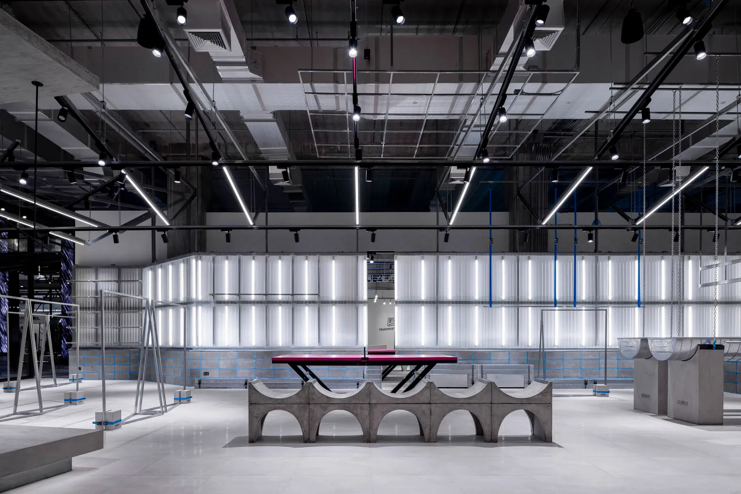 A modern industrial interior space featuring concrete materials, white lighting, and minimalist design.