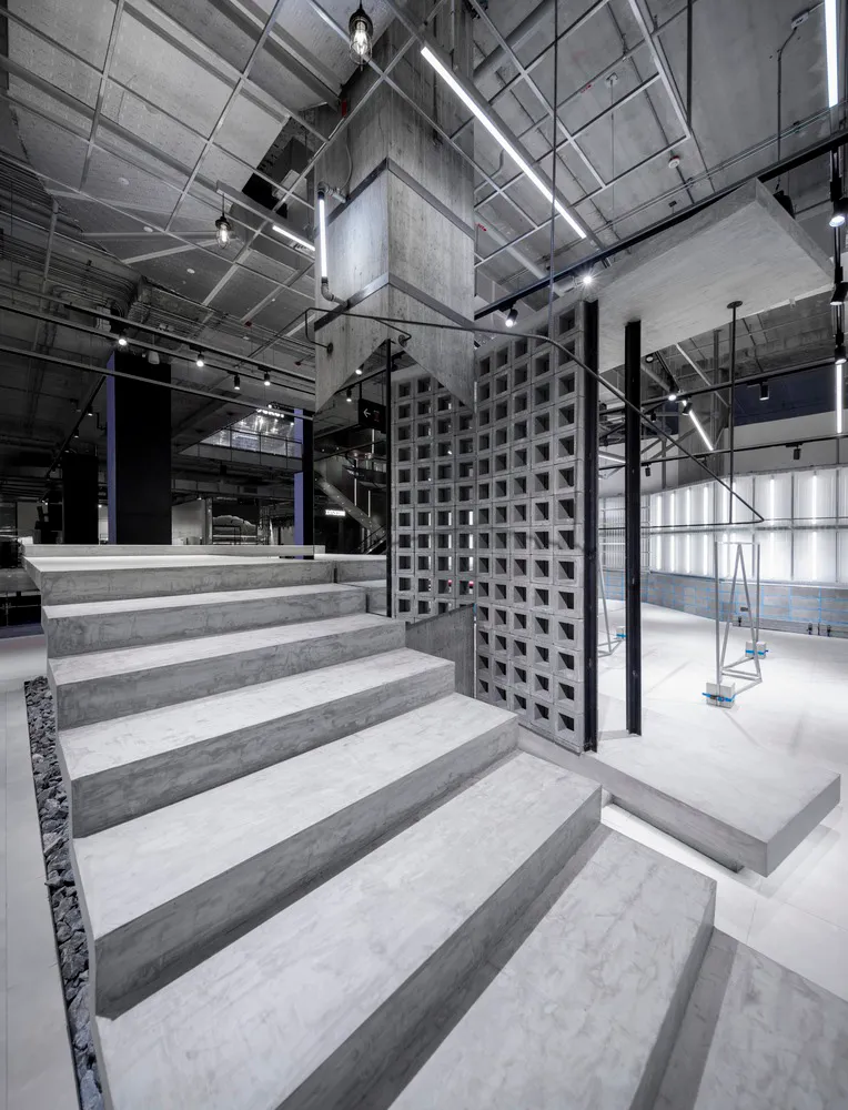 A modern commercial space with exposed concrete walls and a staircase.