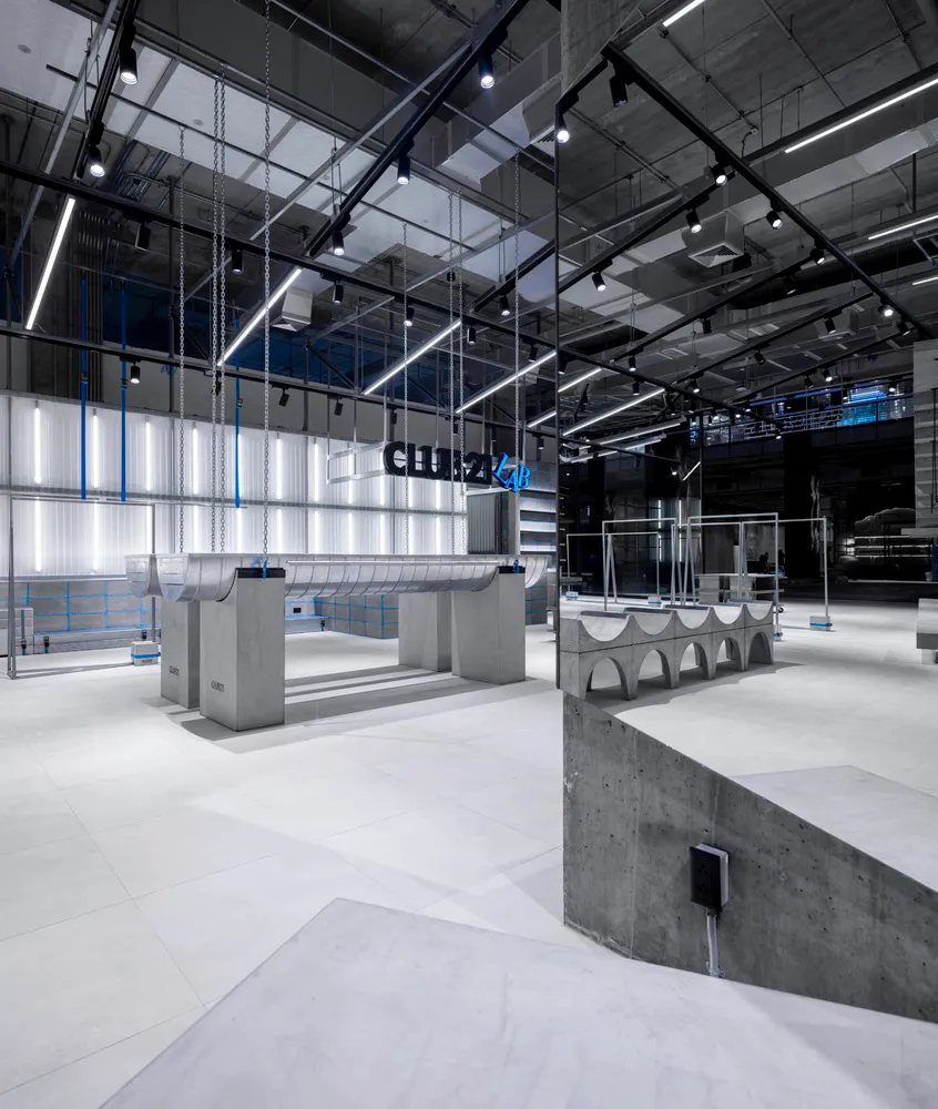 Modern storefront with concrete elements and industrial-style lighting.