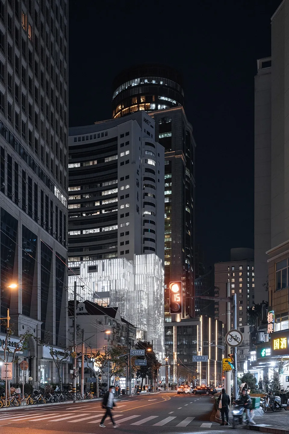 夜間城市景觀,燈火通明的建築與街燈,以及行人與車輛穿梭的繁忙街道。