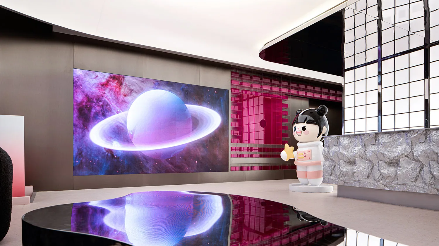 A modern shop interior featuring a large LED screen displaying a planet with a ring system.