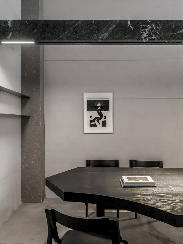 A minimalist black wooden table with a concrete wall background.