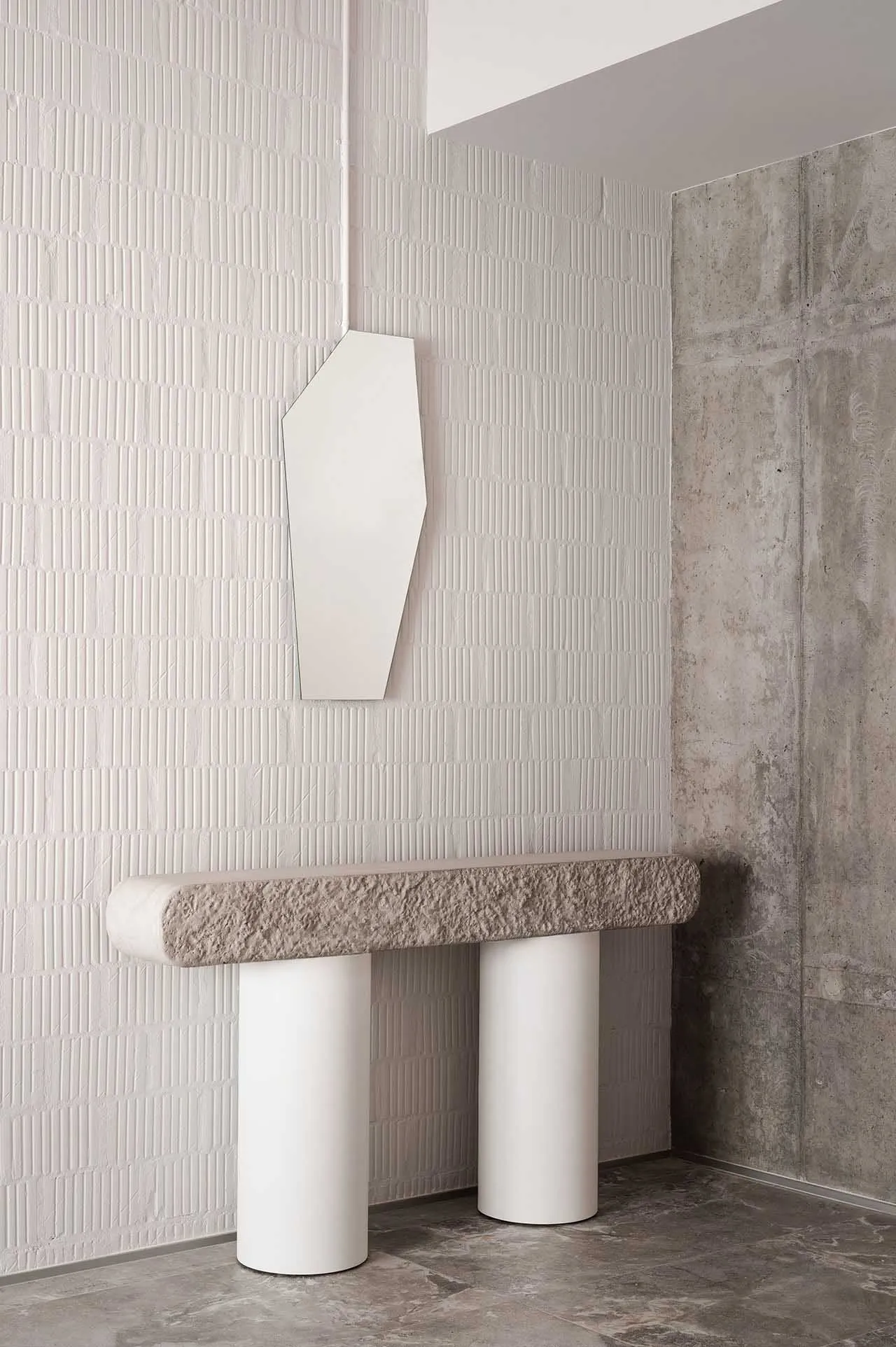 Modern minimalist console table with geometric shapes, featuring two cylindrical white bases topped with a textured gray terr