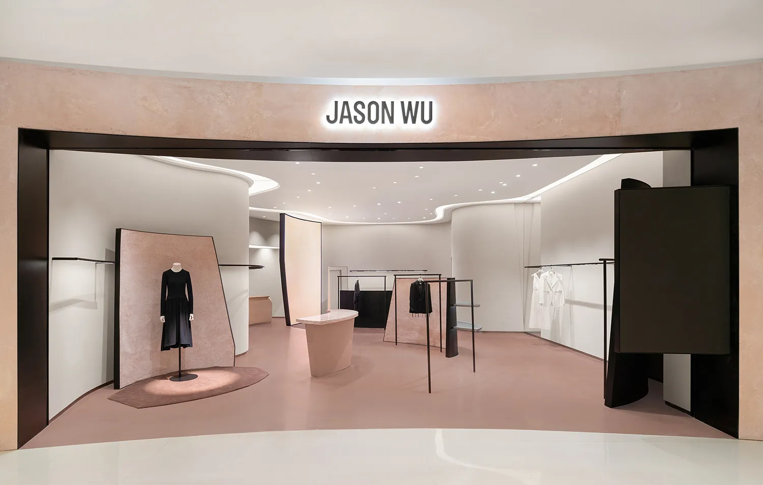 A minimalist fashion shop featuring a sleek, modern design with a pink flooring and a black and white color scheme.
