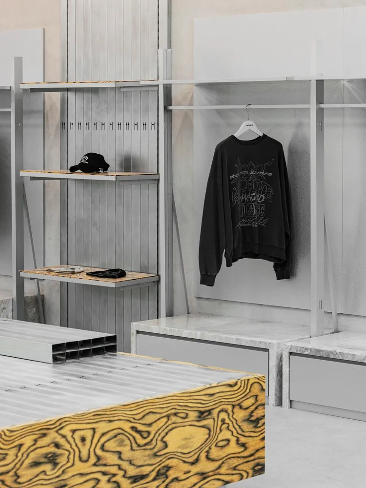 極簡服裝零售展示，搭配工業風金屬層架與大理石檯面。