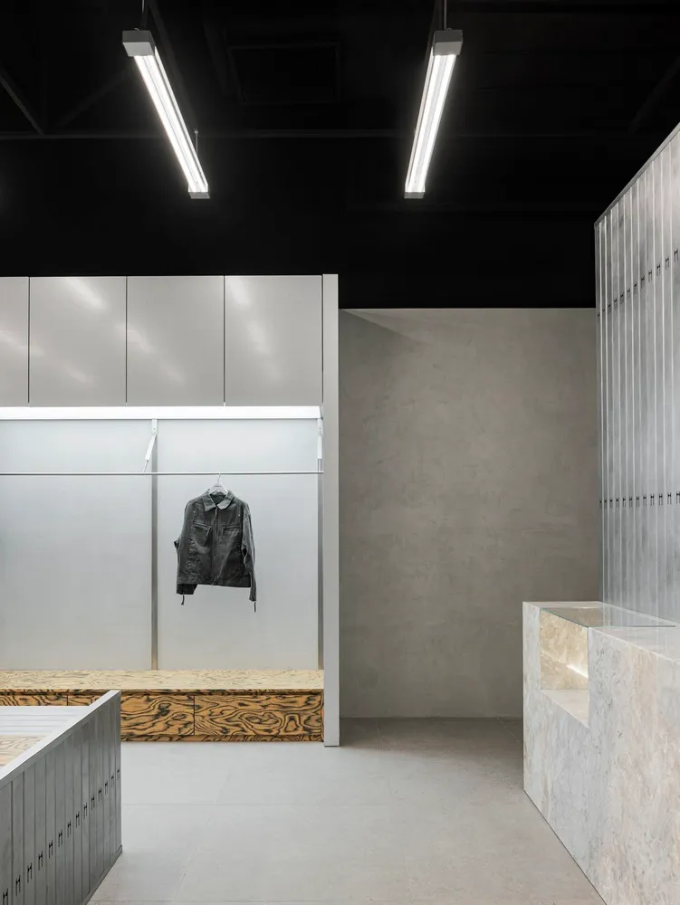 A minimalist retail store featuring metal, concrete, and wood materials.