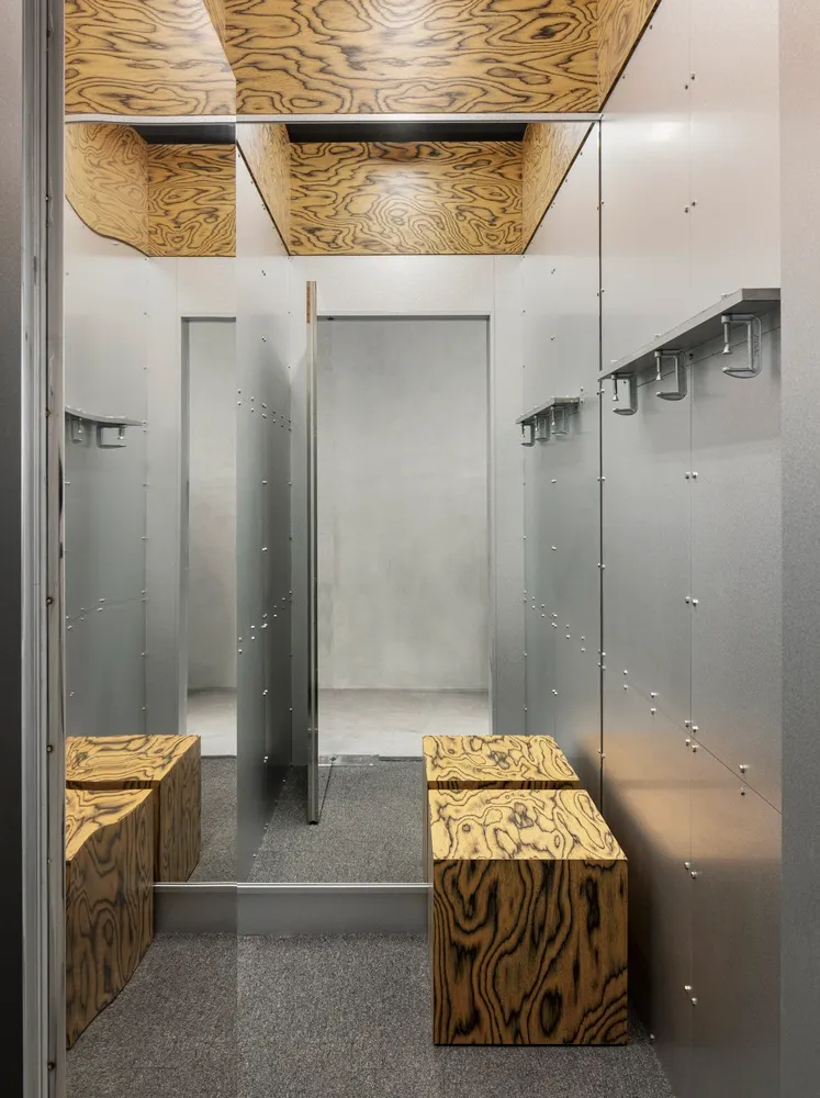現代工業風服裝店更衣室，搭配木紋板材與金屬點綴