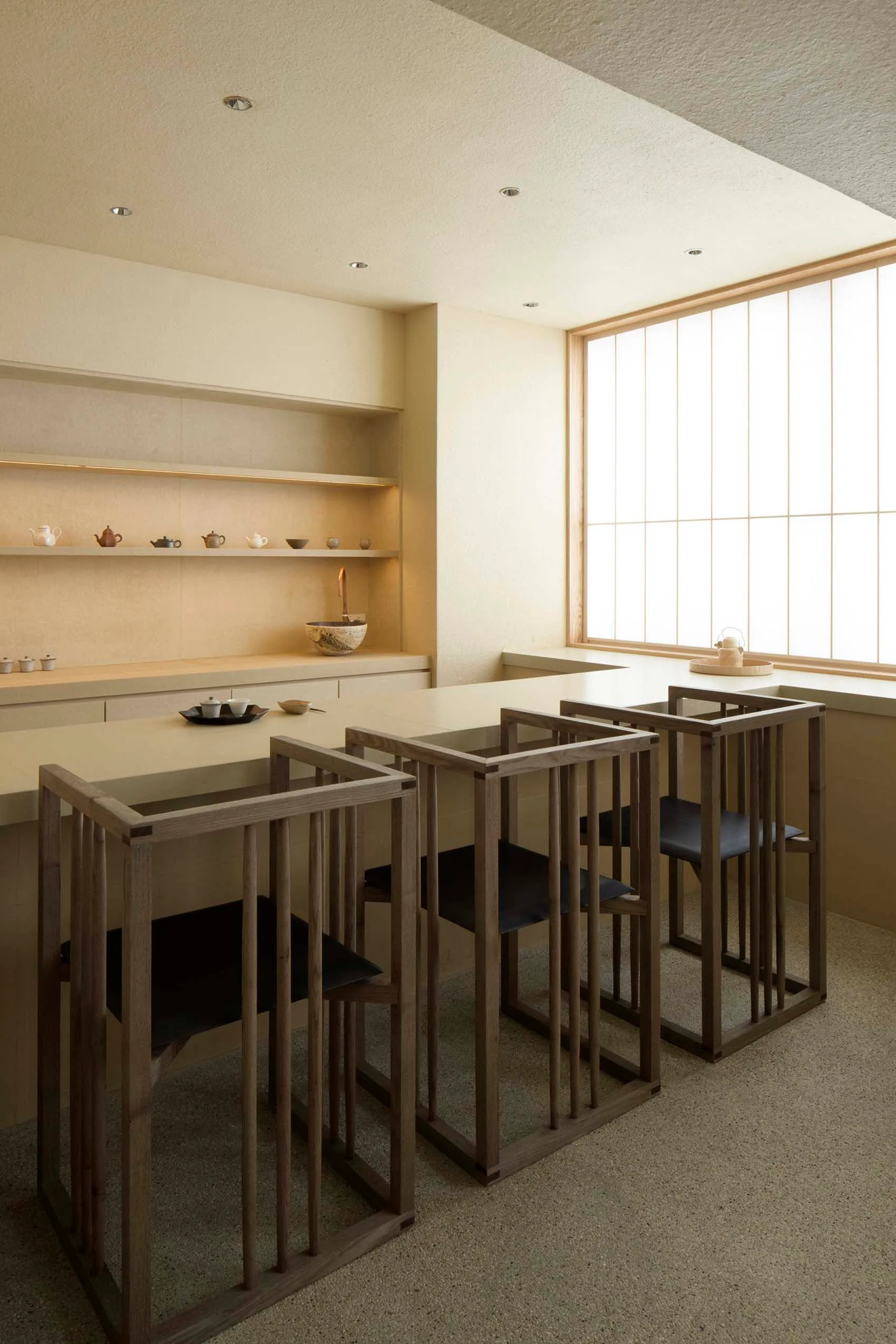 A modern kitchen bar area with wooden structures and black seating.