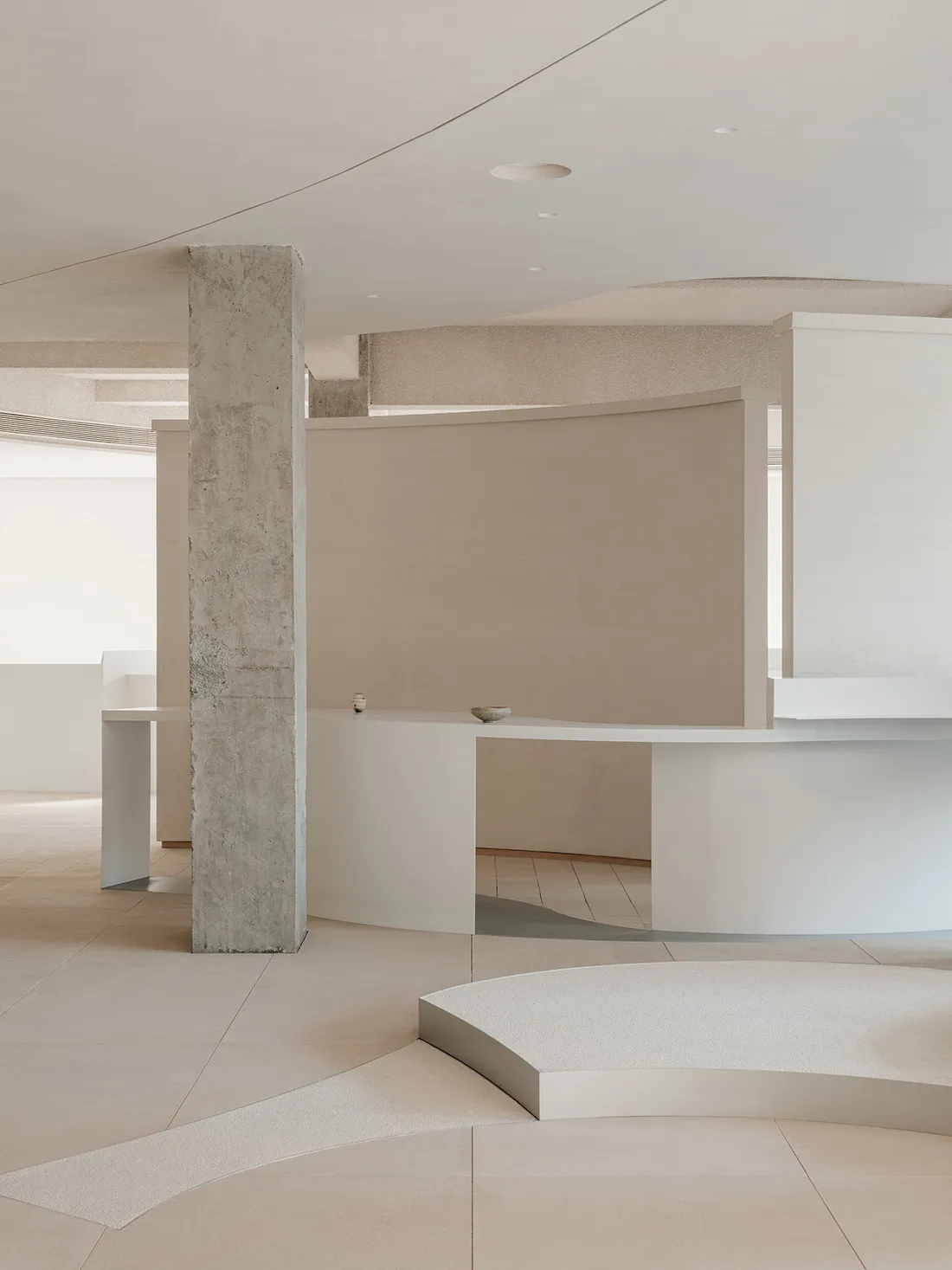 Modern, minimalist living room featuring polished concrete flooring and sleek, contemporary furniture.