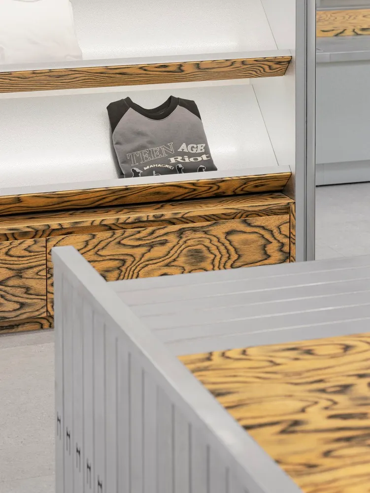 A retail display featuring a wooden counter with a t-shirt on a shelf.