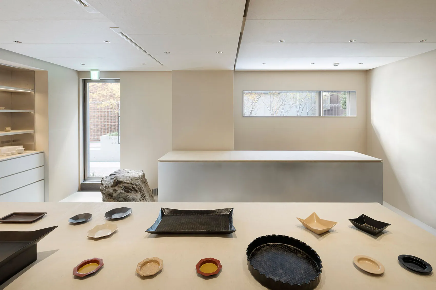 A display of ceramic tableware on a light-colored table against a light wall background.