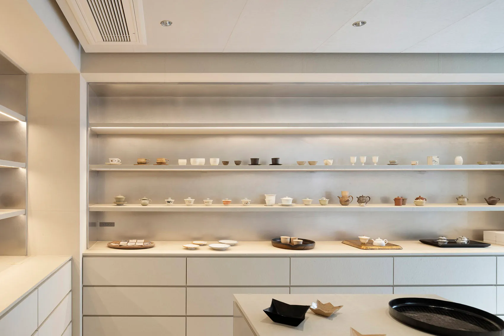 Shelves displaying ceramic tea cups and teapots.