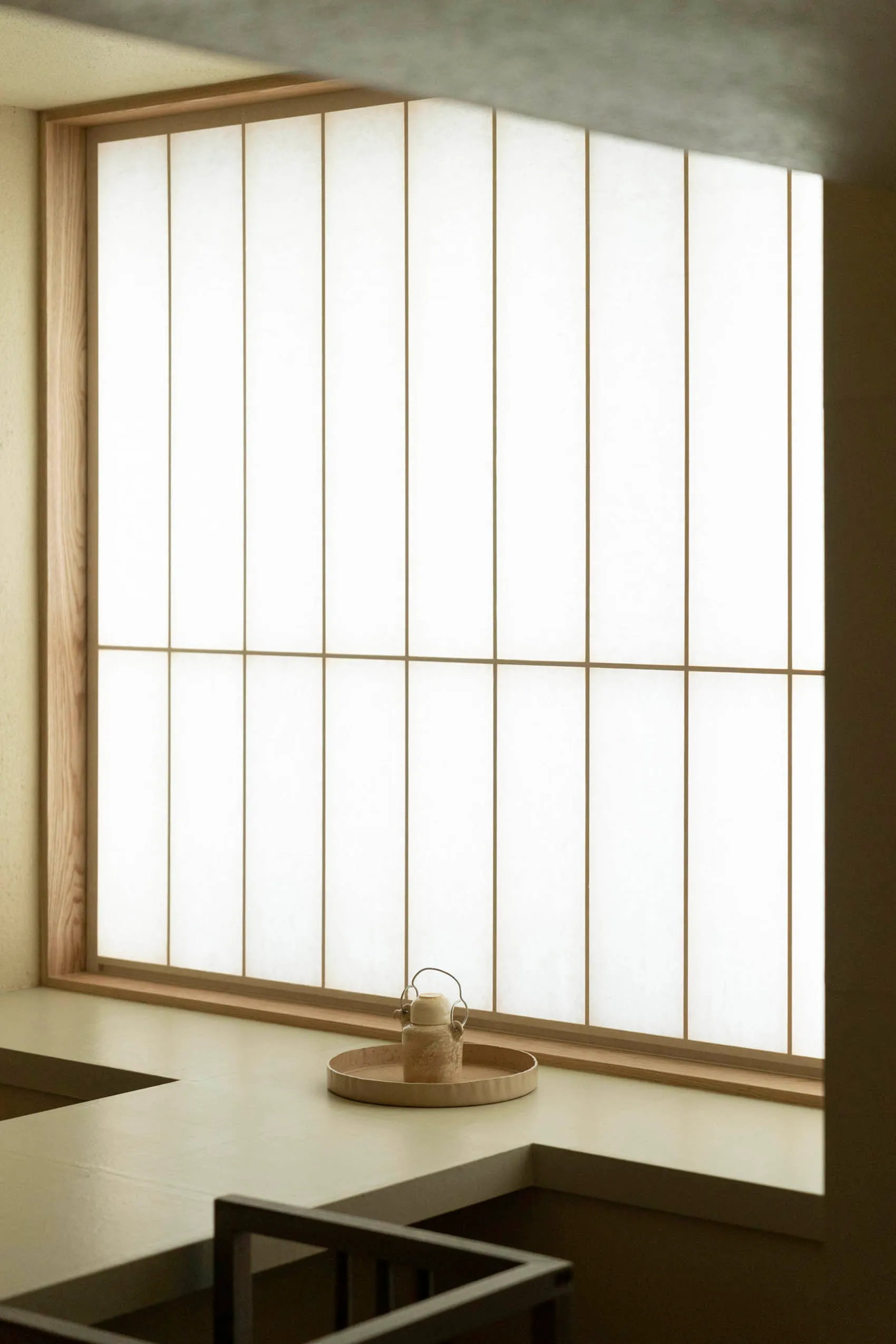 A minimalist interior with white paper shoji screens and soft lighting.