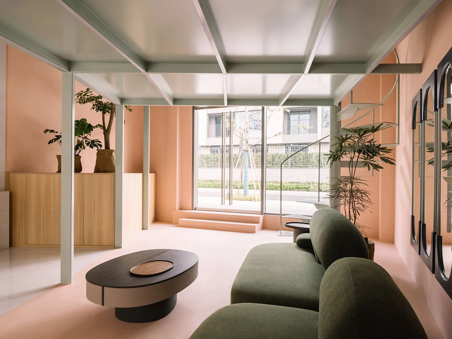 A modern minimalist living room with concrete floors, wood furniture, and green plants