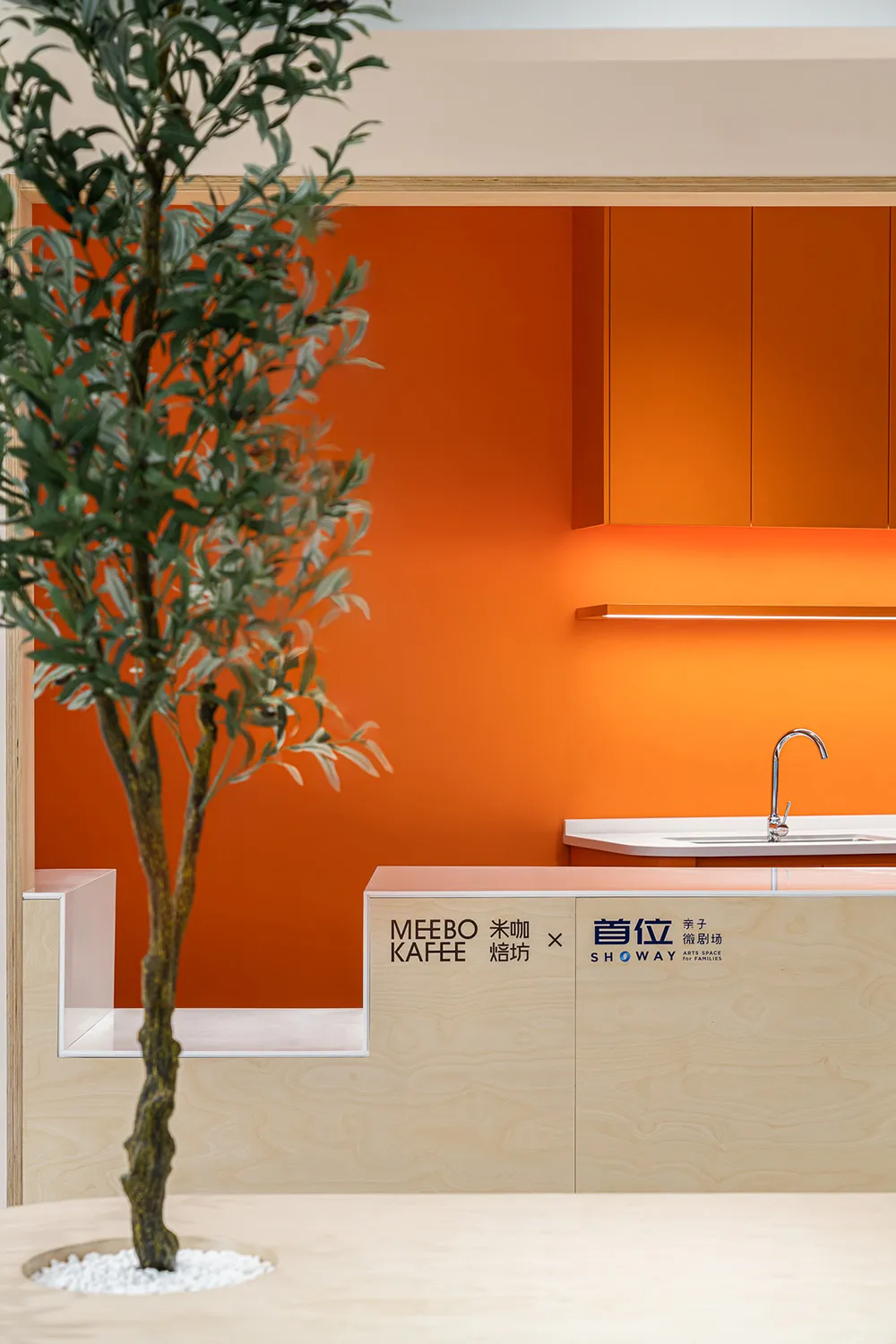 A minimalist restaurant interior featuring orange and white materials.